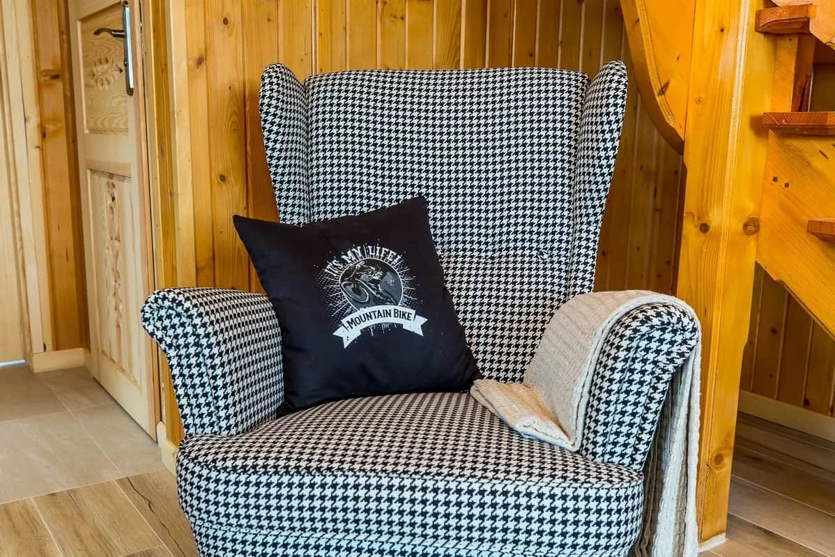 Hahnentritt-Sessel mit Kissen im Holzinterieur des Ferienhauses
