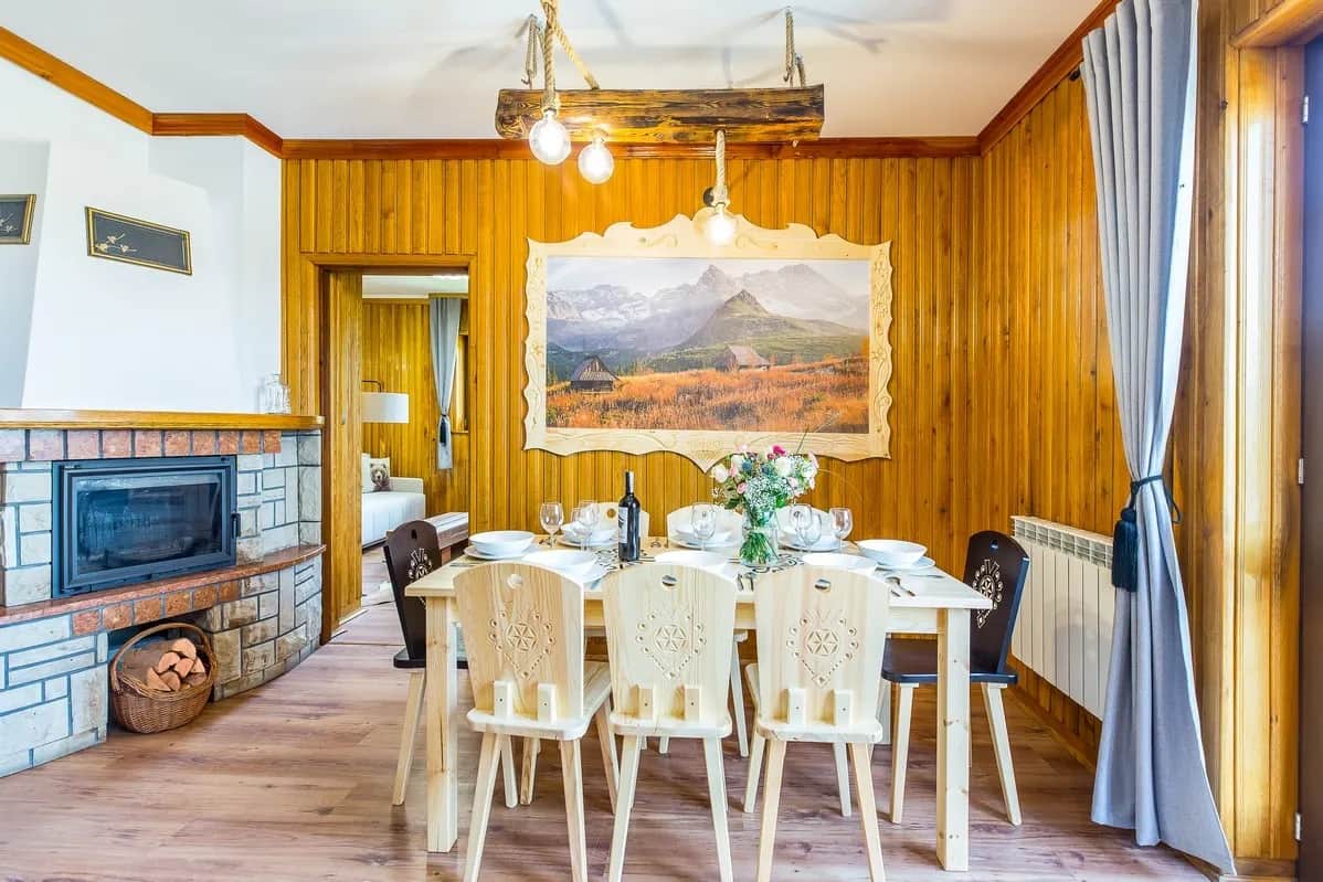Essbereich mit Holztisch, Stühlen im Góralen-Stil und Kamin