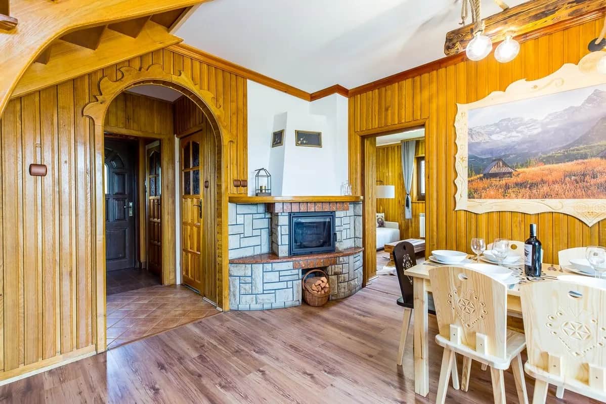 Gemauerter Kamin und Essbereich im Holzinterieur des Ferienhauses