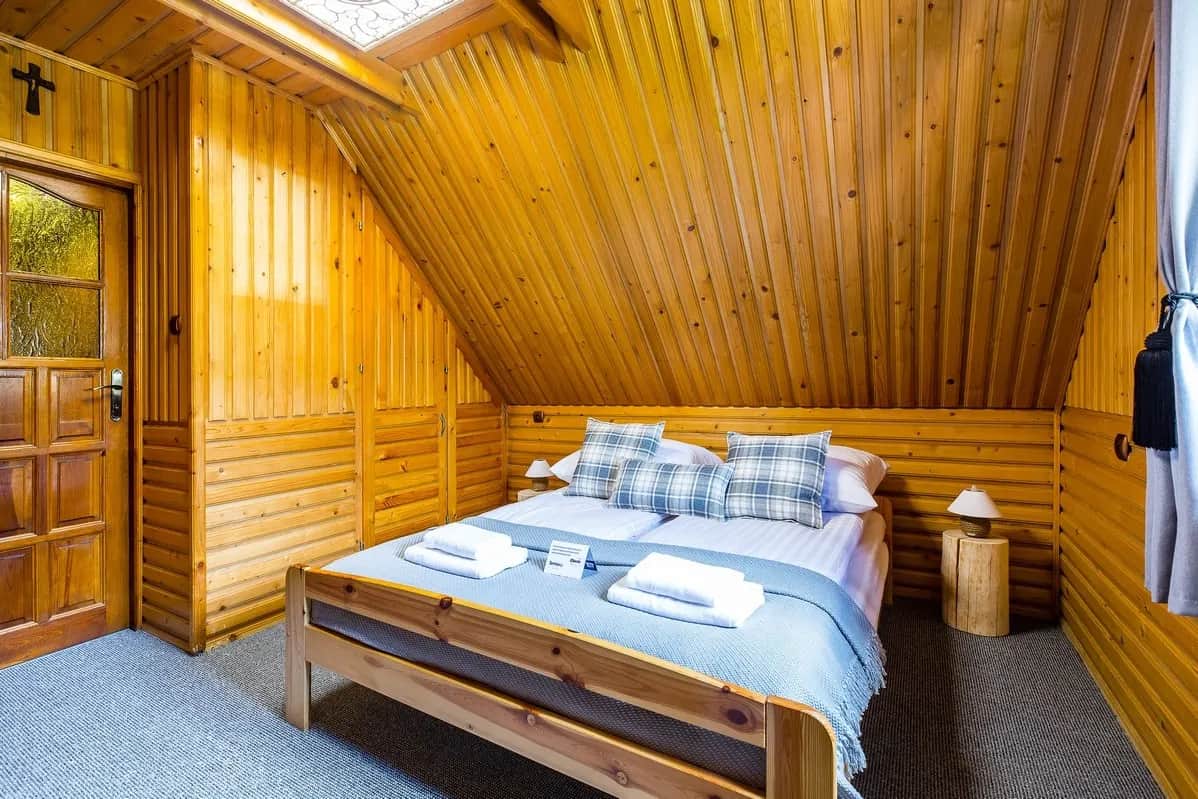 Gemütliches Schlafzimmer mit großem Bett im Holzinterieur