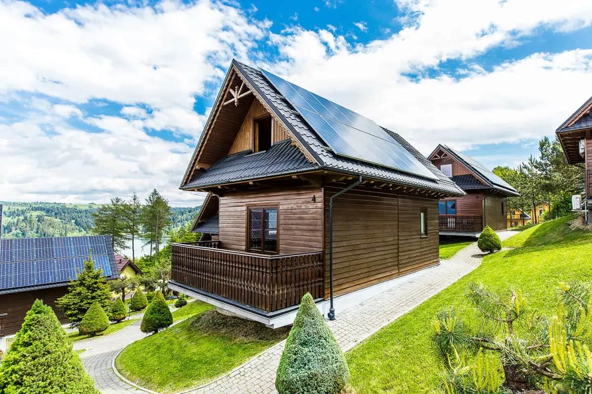Ferienhaus mit Solarpaneelen und Terrasse vor Hügelkulisse