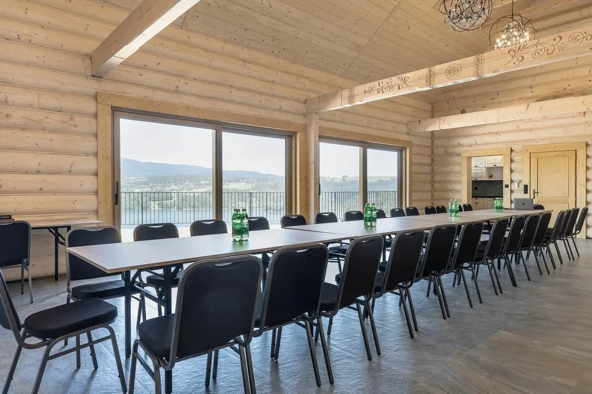 Blockbau-Konferenzraum mit langem Tisch und Seeblick