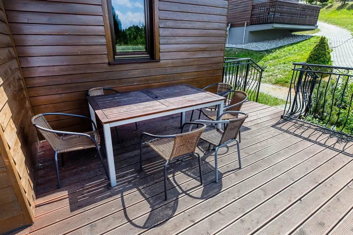 Holzterrasse des Ferienhauses mit Tisch und Stühlen an einem sonnigen Tag